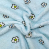 Fleet comforter printed with flowers and ducklings on a sky blue background