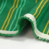 Sudadera de peluche a rayas amarillas y verde mar con fondo verde prado