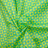 Coated poplin printed with fields of flowers, green lemon background