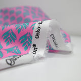 Popeline enduite imprimée végétal turquoise fond rose