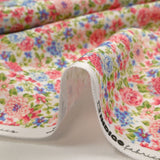 Piqué de coton imprimé les fleurs de Sarah bleu et fraise fond blanc