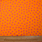 Crêpe satin de polyester imprimé à pois roses fond orange
