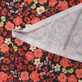 Crêpe polyester imprimé fleurs corail fond marron