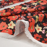 Crêpe polyester imprimé fleurs corail fond marron