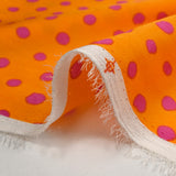 Crêpe satin de polyester imprimé à pois roses fond orange