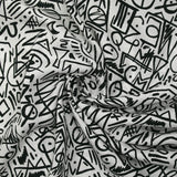 Viscosa estampada con graffitis negros sobre fondo blanco