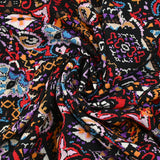 Viscose imprimée frénésie orange, rouge et violet fond noir
