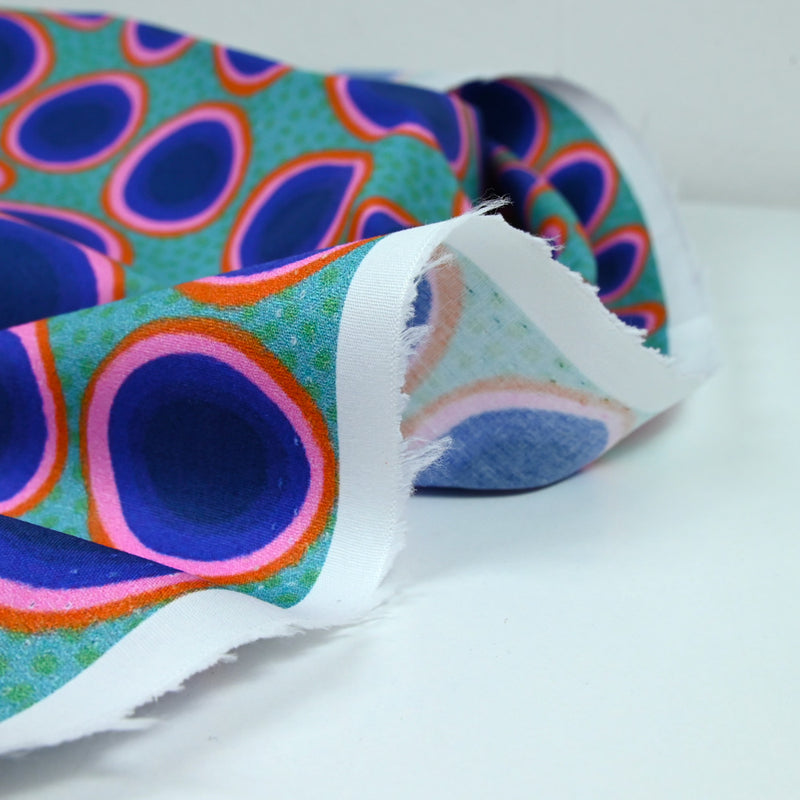 Coton imprimé rond rose, orange et bleu fond vert