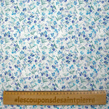 Bordado inglés estampado con pequeñas flores azules sobre fondo blanco.