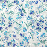 Bordado inglés estampado con pequeñas flores azules sobre fondo blanco.