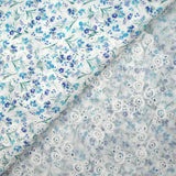 Bordado inglés estampado con pequeñas flores azules sobre fondo blanco.