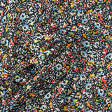 Mousseline crinkle imprimée irisée miette de fleur fond noir