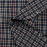 Tejido de polialgodón teñido con cuadros azul marino y burdeos oscuro sobre un fondo gris moteado.