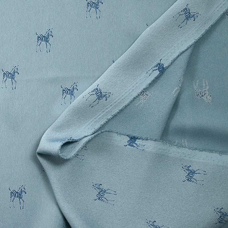 Crêpe satin de polyester imprimé zèbre fond bleu charrette