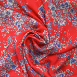 Satin polyester imprimé fleurs pastel fond rouge