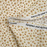 Popelina de algodón estampada con flores abstractas sobre fondo crudo