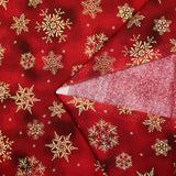 Cotton poplin printed with golden snowflakes on a red marbled background