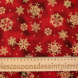 Cotton poplin printed with golden snowflakes on a red marbled background