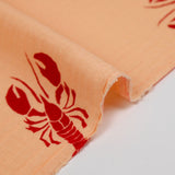 Gasa doble estampada con fondo rojo bogavante y albaricoque