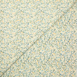 Voile de coton imprimé digital fleurettes jaunes et feuillage vert sur fond crème
