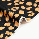 Crêpe satiné de polyester sauvage mordoré fond noir