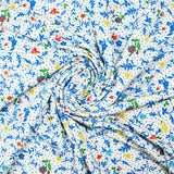 Jersey de viscose satiné imprimé fleurs bleues fond confetti multicolore