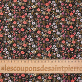 Prado de voile de algodón con estampado digital de pequeñas flores de color naranja y amarillo mantequilla sobre fondo negro