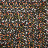 Prado de voile de algodón con estampado digital de pequeñas flores verdes y naranjas sobre fondo negro