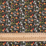 Prado de voile de algodón con estampado digital de pequeñas flores verdes y naranjas sobre fondo negro