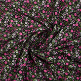 Prado de voile de algodón con estampado digital de pequeñas flores fucsia y verde manzana sobre fondo negro