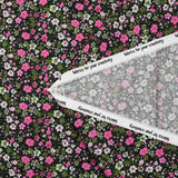 Prado de voile de algodón con estampado digital de pequeñas flores fucsia y verde manzana sobre fondo negro