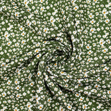Viscosa estampada con flores blancas y amarillas, fondo caqui.