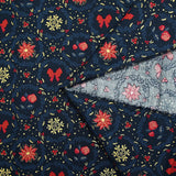 Popelina de algodón estampada con flores de pascua y lazos rojos sobre fondo azul marino