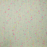 Tweed de laine mélangée confettis rose et bleu fond vert