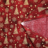 Cotton poplin printed with golden fir trees on a red marbled background