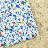 Jersey de viscose satiné imprimé fleurs bleues fond confetti multicolore