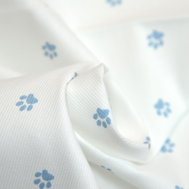 Tissus Piqué de coton imprimé pattes de chien bleues sur fond blanc