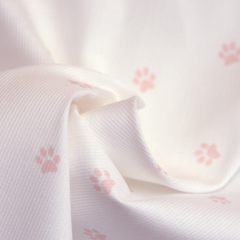 Tissus Piqué de coton imprimé pattes de chien roses sur fond blanc